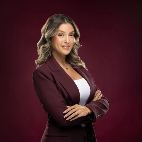 Corporate headshot photography Dubai - female business professional in burgundy blazer with arms crossed, studio portrait by Masoud Raoufi Photography UAE
