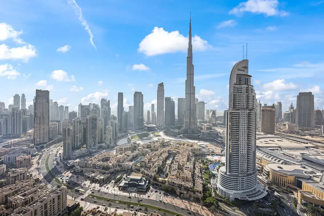 Aerial view of Dubai's skyline with the Burj Khalifa among many high-rise buildings on a sunny day.