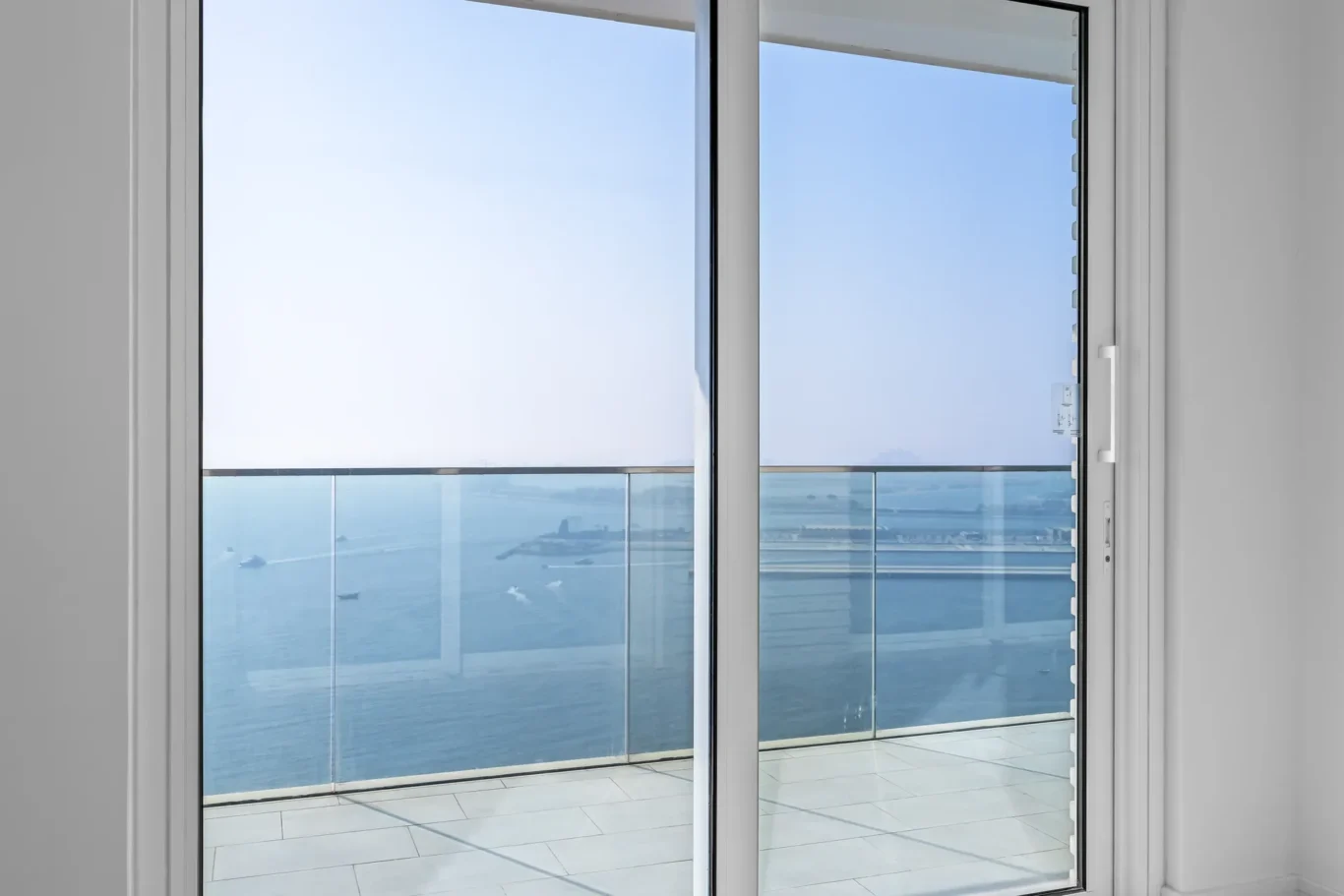 Sliding glass door opening to a balcony with a glass railing and ocean view (boats in the water).]} }? Wait extra. I messed. Must provide array of strings not bracket with extra. Let's provide proper format.