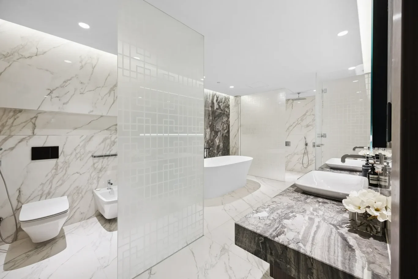 Luxurious marble bathroom with a freestanding tub, glass partition, and double sinks; glossy surfaces and modern fixtures.