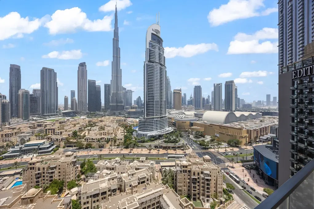 Dubai skyline with Burj Khalifa at center, surrounded by skyscrapers and a busy urban district.