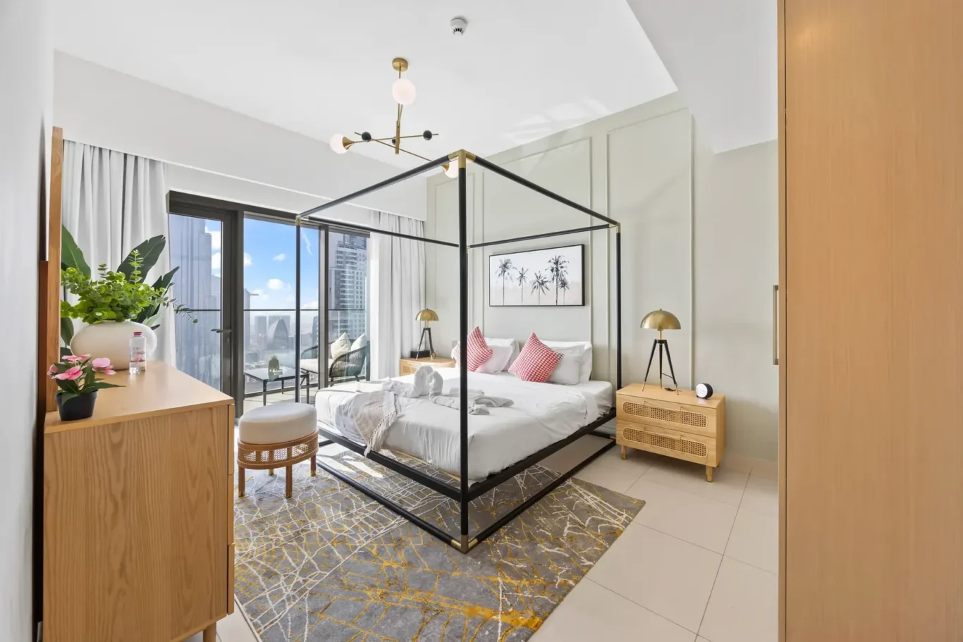 Hotel bedroom with a black metal four-poster bed, white bedding, and gold-accent lamps, overlooking a city balcony.”](https://)