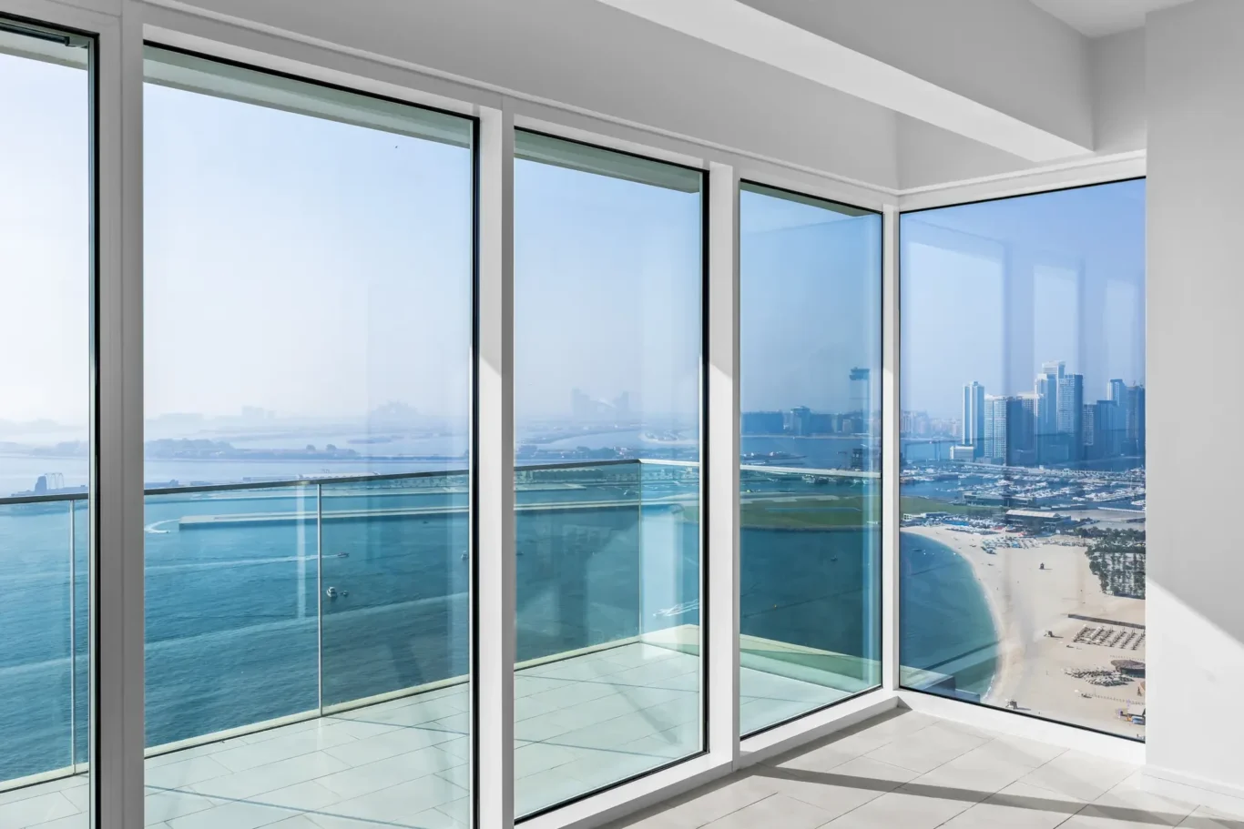 Interior with floor-to-ceiling windows overlooking the ocean and city skyline outside the glass walls?