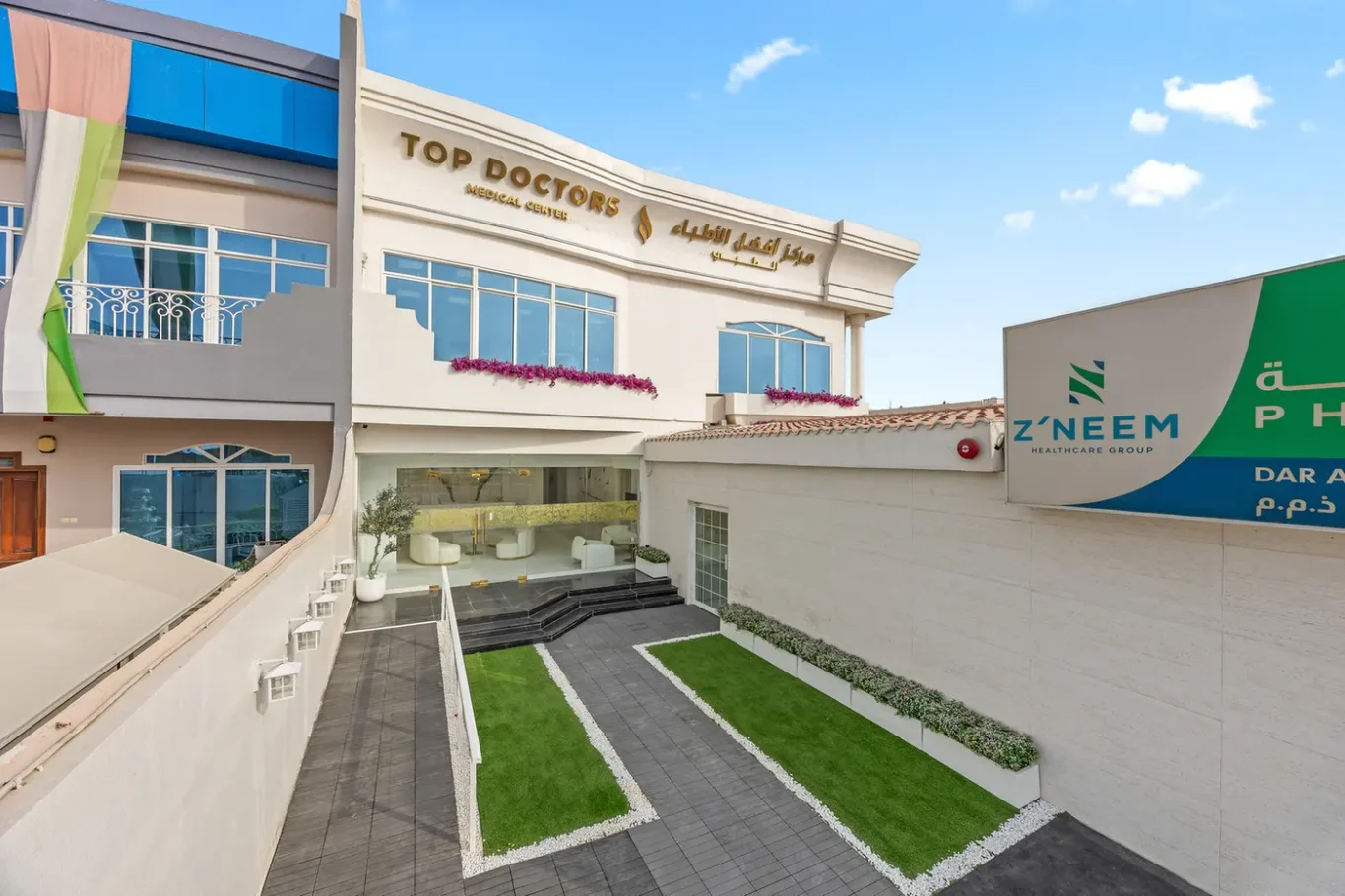 Exterior view of Top Doctors Medical Center with glass entrance doors and manicured courtyard