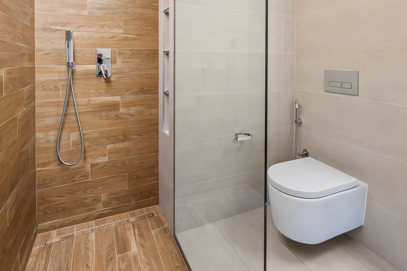 Modern bathroom with a wood-look tiled shower area, glass partition, and a wall-mounted toilet with a chrome flush plate.