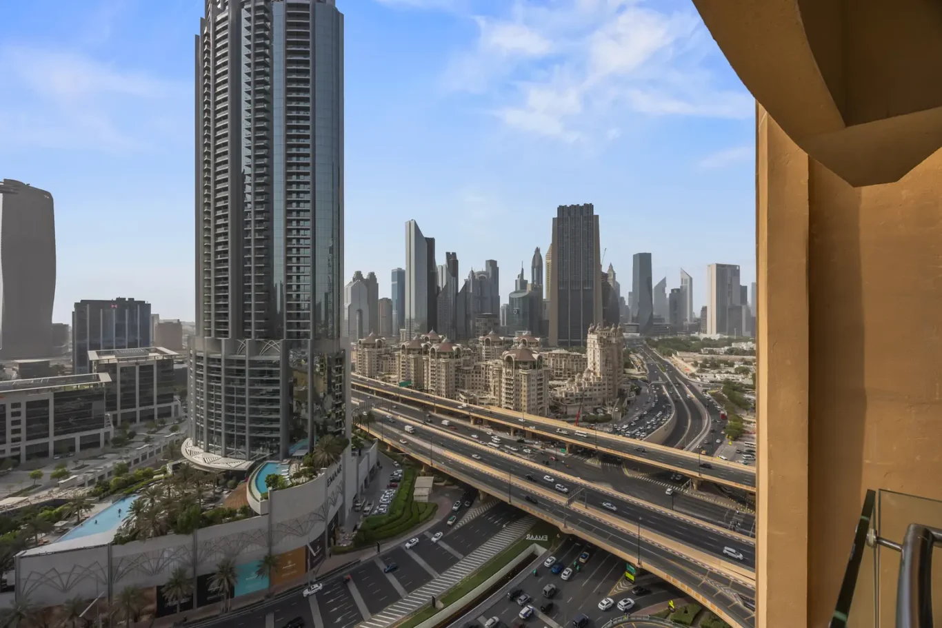 Urban cityscape with tall glass skyscrapers and a multi-lane highway below, taken from a balcony?is this the right phrasing?
