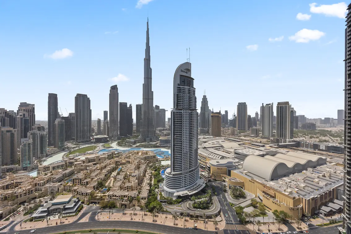 Aerial view of Downtown Dubai with Burj Khalifa, surrounding skyscrapers, and the Dubai Mall complex.