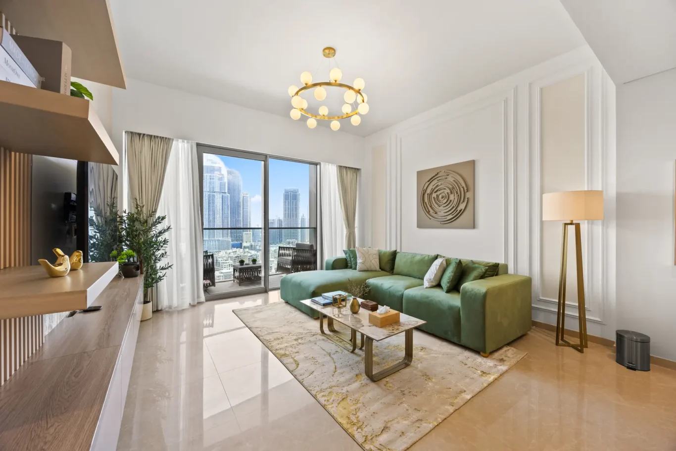 Bright living room with a green sectional sofa, marble coffee table, and a cityscape view through glass doors.