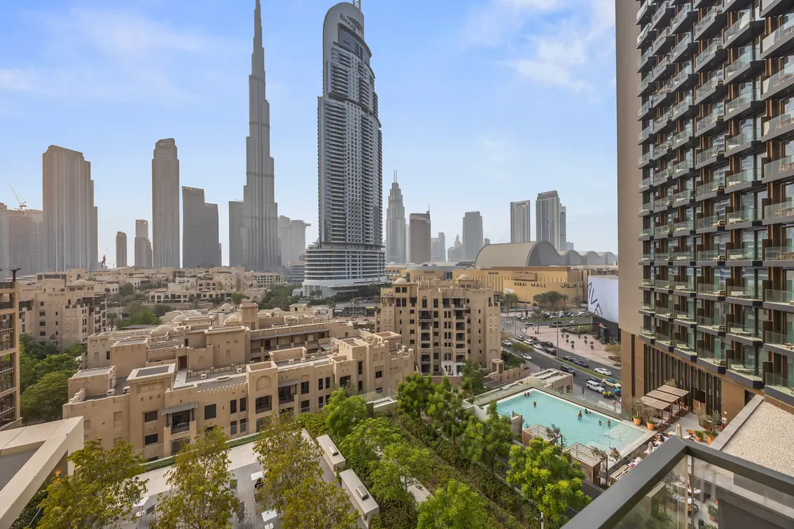 Dubai skyline with the Burj Khalifa at center, surrounded by skyscrapers and a foreground pool deck.