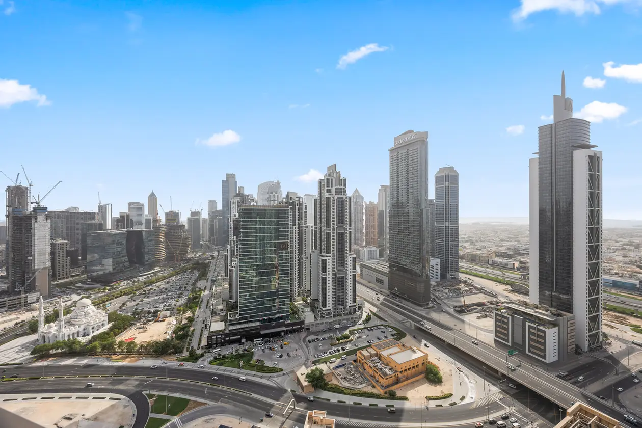 Modern city skyline with tall glass skyscrapers and a network of elevated highways below.