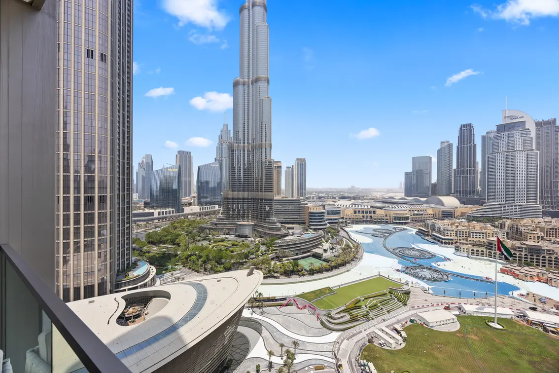 Cityscape of Dubai featuring the Burj Khalifa towering over modern skyscrapers and a futuristic, curved plaza in the foreground.