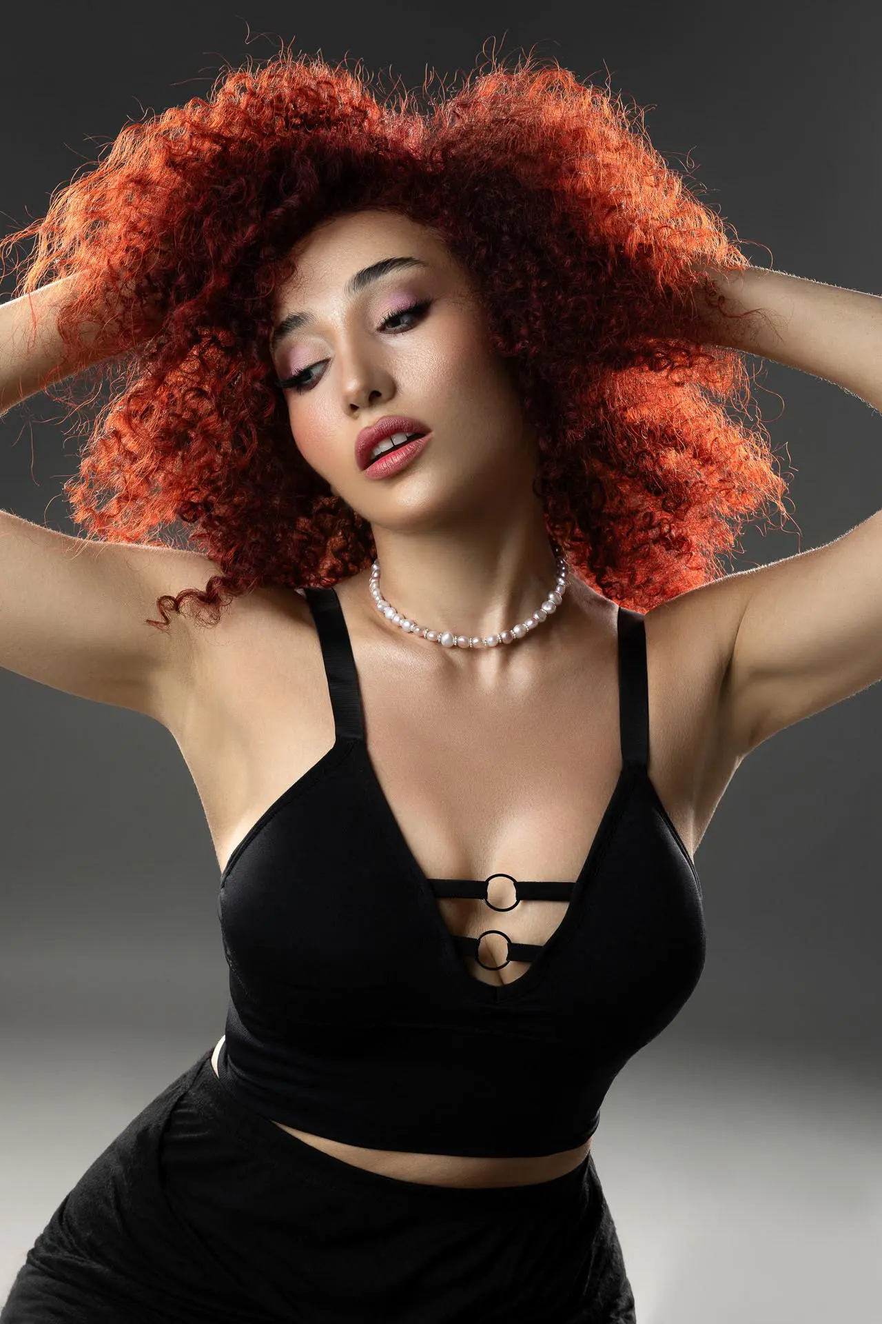 Editorial fashion photography of a woman with red curly hair at a Dubai photo studio