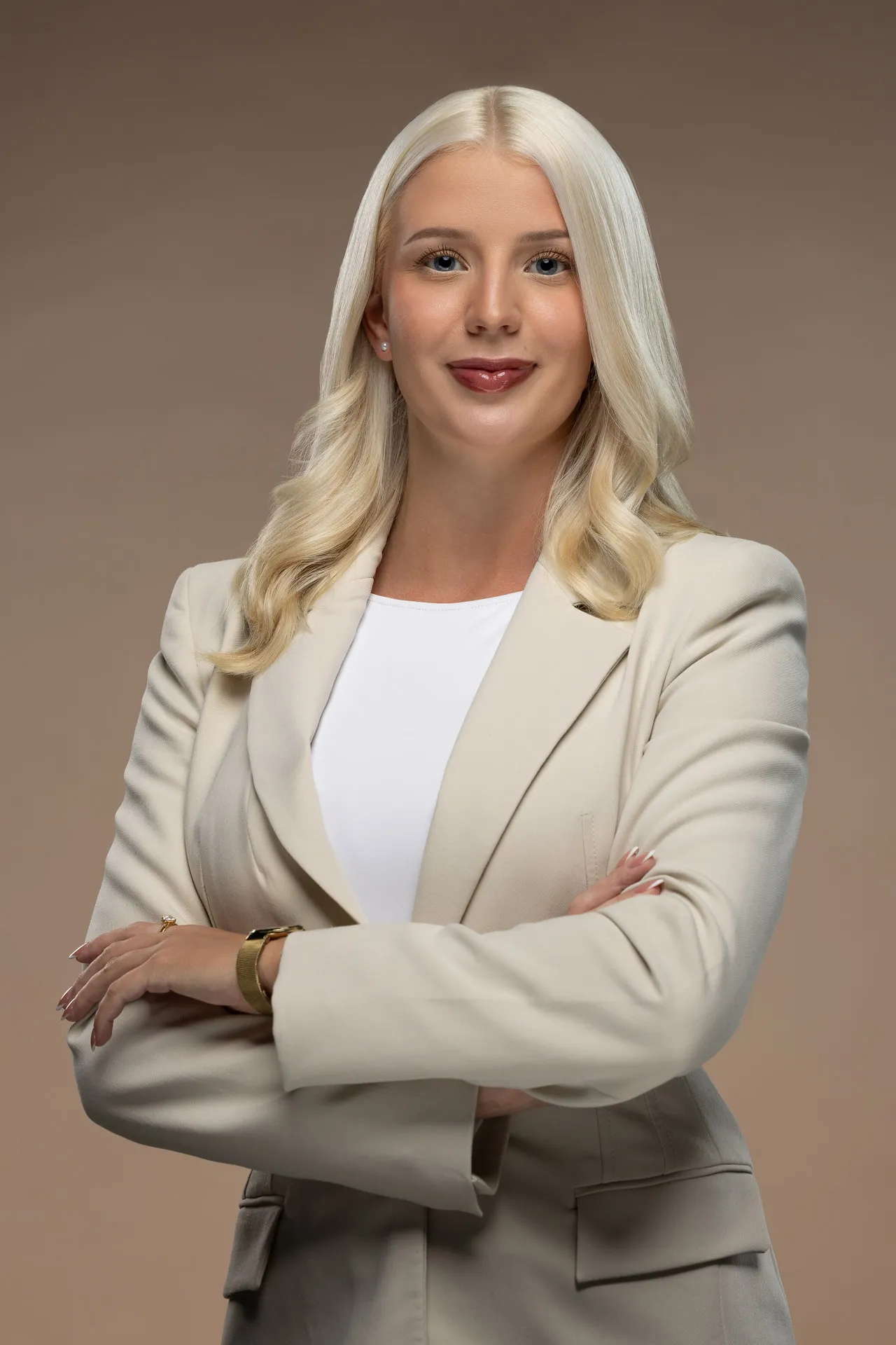 Corporate headshot photography Dubai - female business professional in cream blazer with arms crossed, professional studio portrait UAE