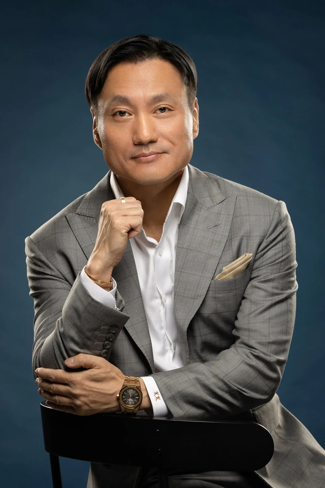 Executive portrait photography Dubai - male corporate professional in gray suit seated studio pose, business headshot UAE