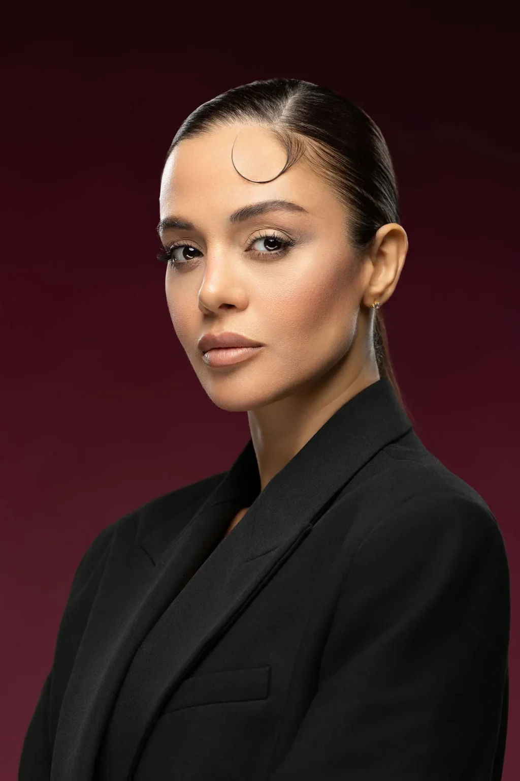 Executive portrait of a woman in a black blazer photographed at a professional studio in Business Bay Dubai