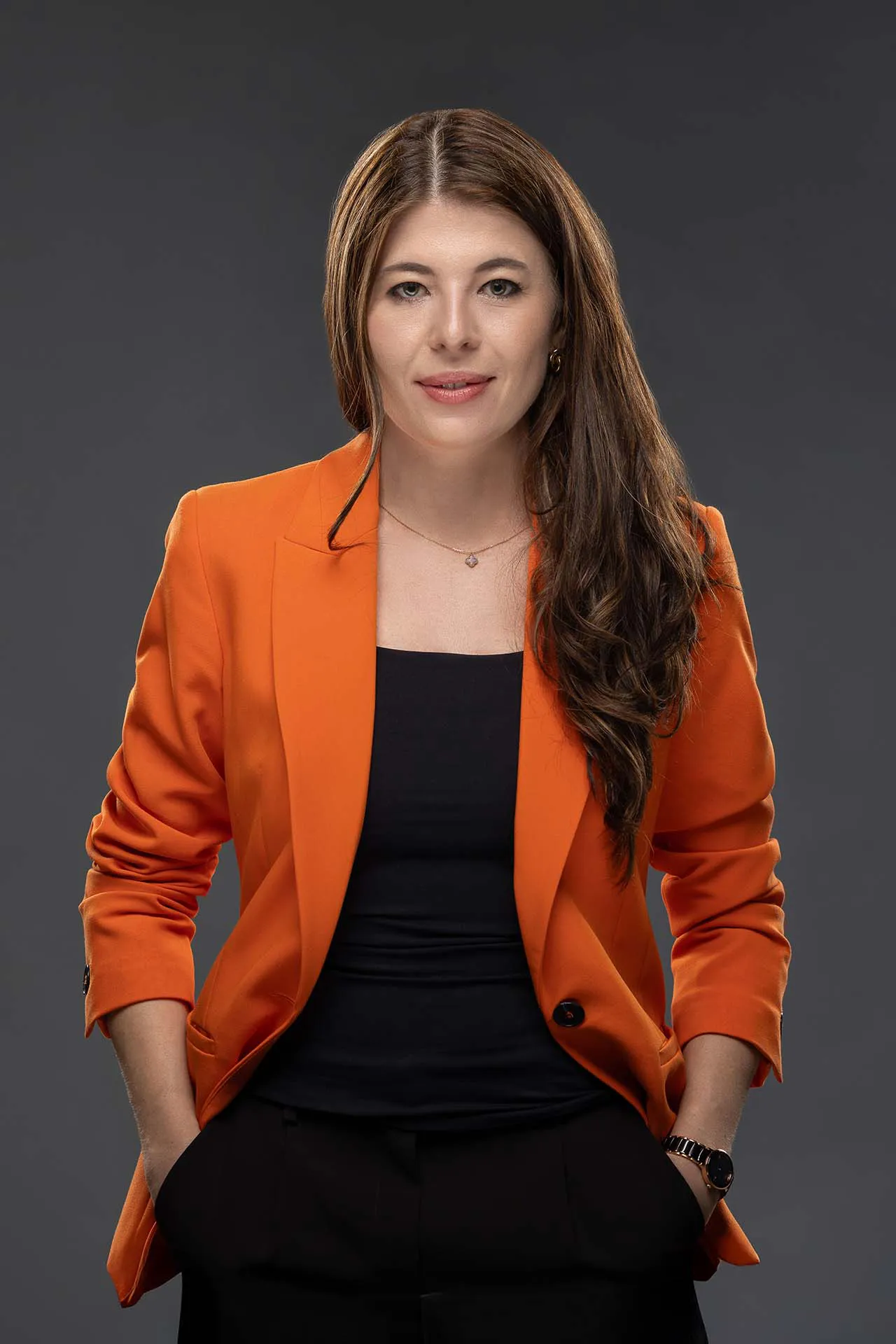 Professional business portrait of a woman in an orange blazer at a Dubai corporate photography studio