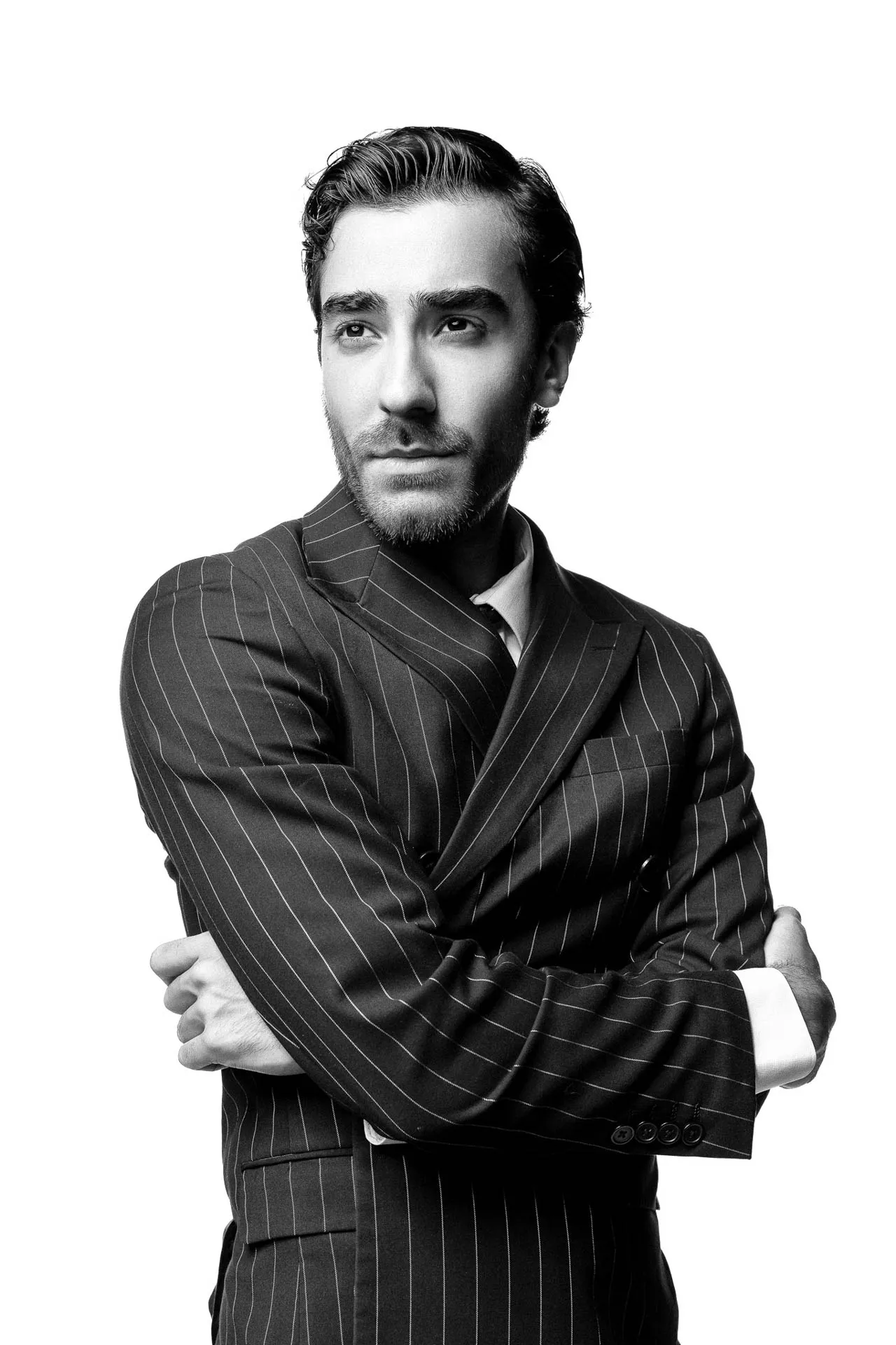 Male model in a pinstripe suit, arms crossed — black-and-white editorial modeling portfolio, Dubai studio