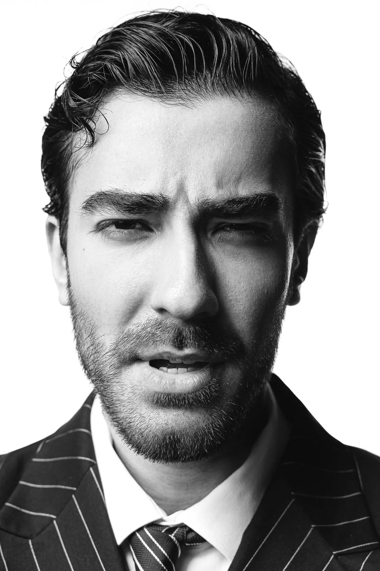 Bearded male model close-up in pinstripe suit and tie — casting-ready portfolio headshot Dubai studio