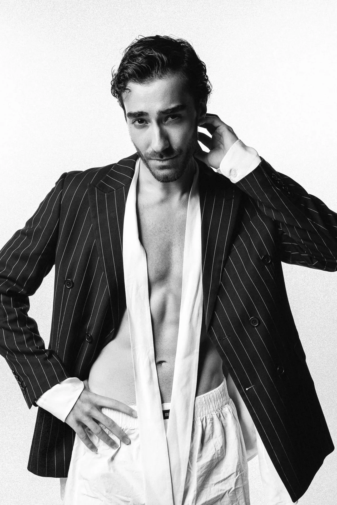 Male model in pinstripe blazer over open white shirt — black-and-white editorial modeling portfolio Dubai