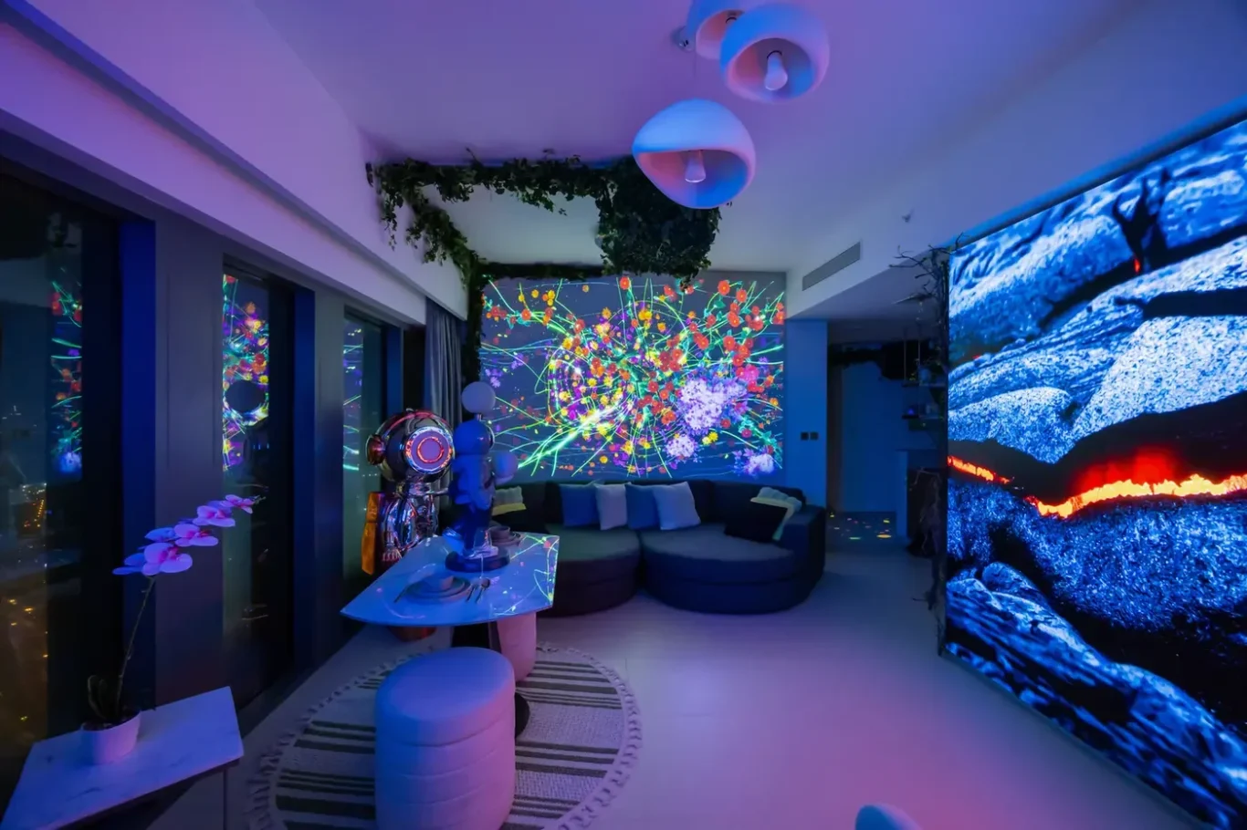 Futuristic living room with a vibrant neon wall mural, curved sofa, and blue lava-screen on the right; plants and abstract art create a sci-fi ambiance.