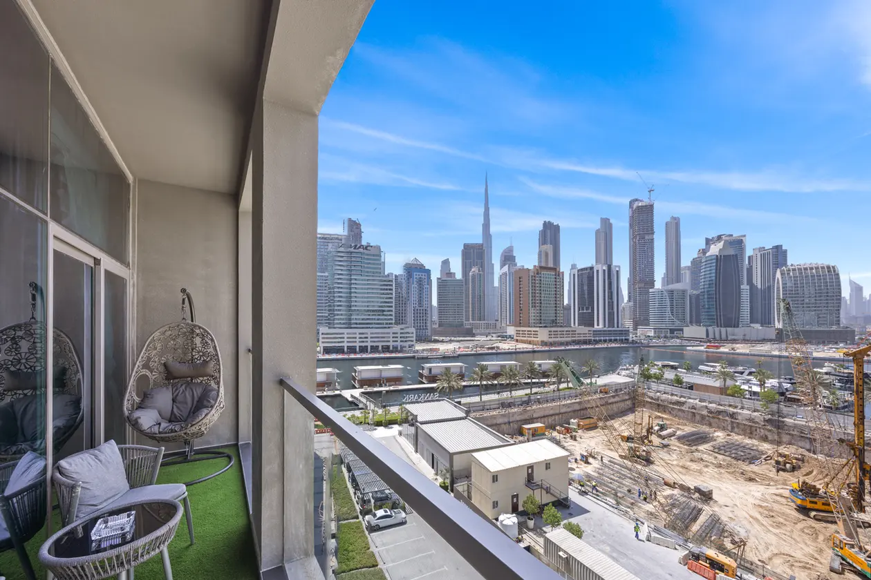 Balcony seating area overlooking a modern city skyline with a construction site in the foreground.
