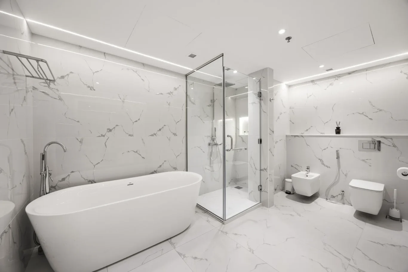 Bright marble bathroom with a freestanding oval tub beside a glass shower enclosure and wall-mounted fixtures.