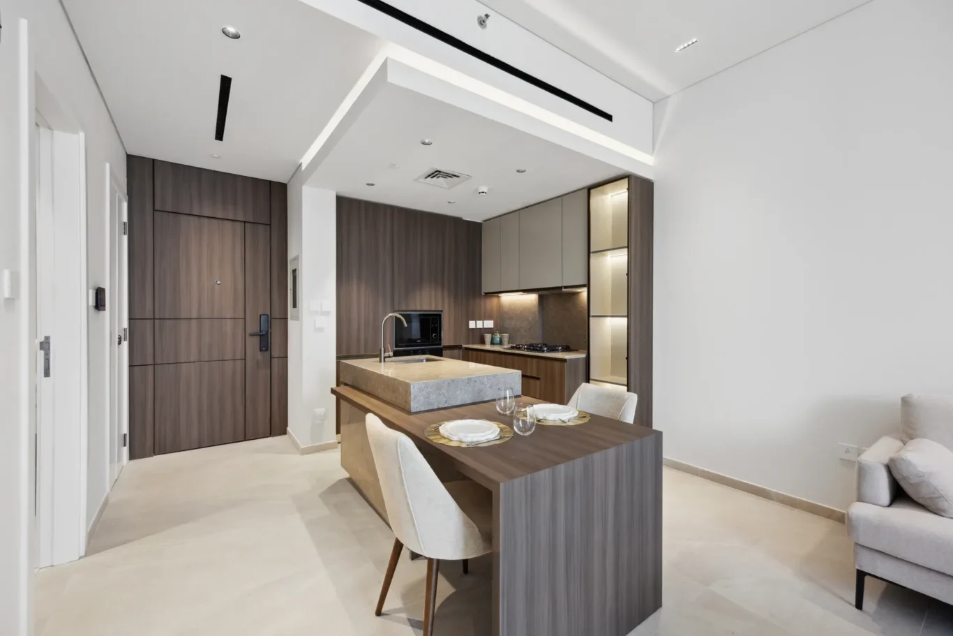Open-plan kitchen with dark wood cabinets, island, and four-seat dining table set for a meal at the island