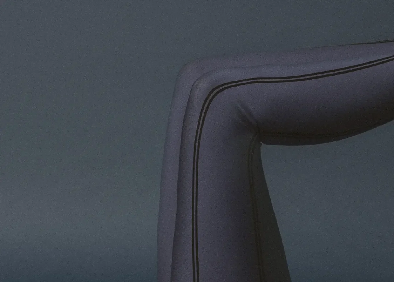 Close-up of a purple inflatable tube corner with dark seam lines against a muted background.