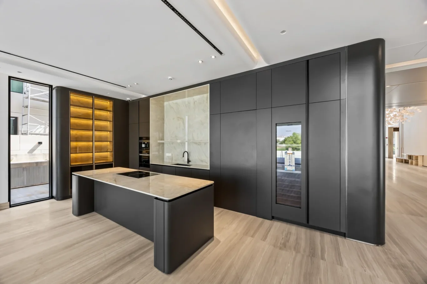 Modern dark-kitchen showroom with a marble island, induction cooktop, and tall cabinetry.