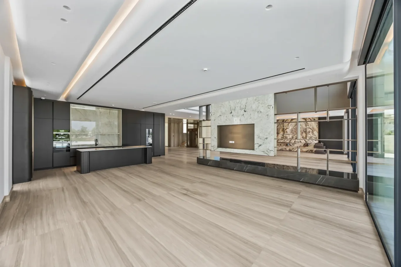 Open-concept showroom lobby with dark cabinetry, marble accents, and glass exterior walls
