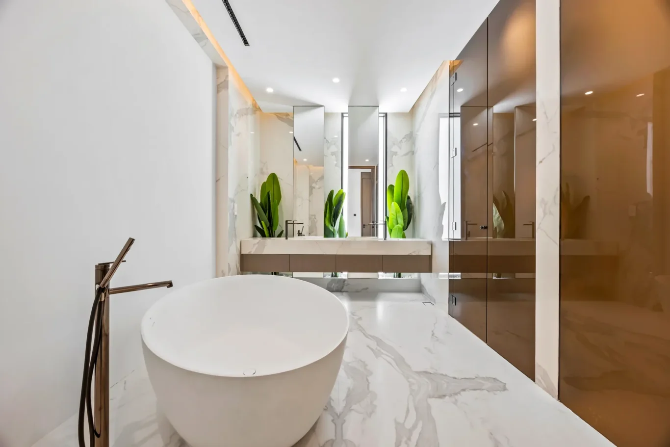 Modern spa-style bathroom with a white freestanding tub, marble floors, and mirrored cabinetry