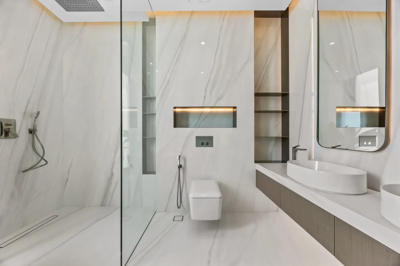 Contemporary marble bathroom with a glass shower enclosure, backlit mirrors, and open shelving.