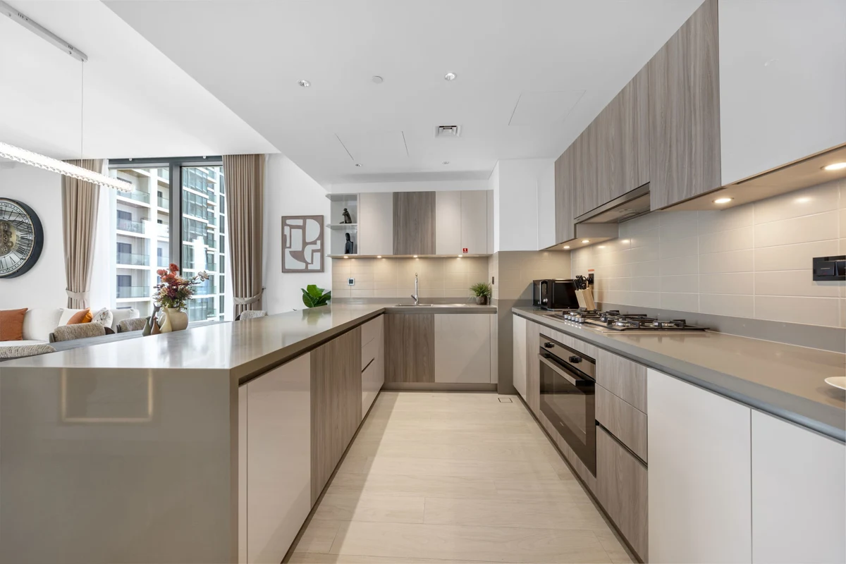 Open-plan kitchen island and dining table of a 3-bedroom Airbnb at Crest Grande, Sobha Hartland, daylight