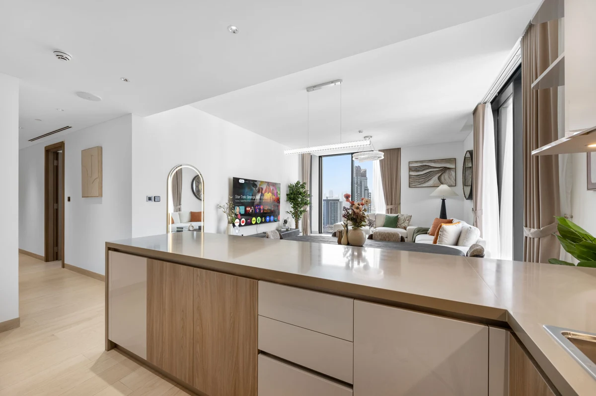 Open-plan kitchen island and dining table of a 3-bedroom Airbnb at Crest Grande, Sobha Hartland, daylight