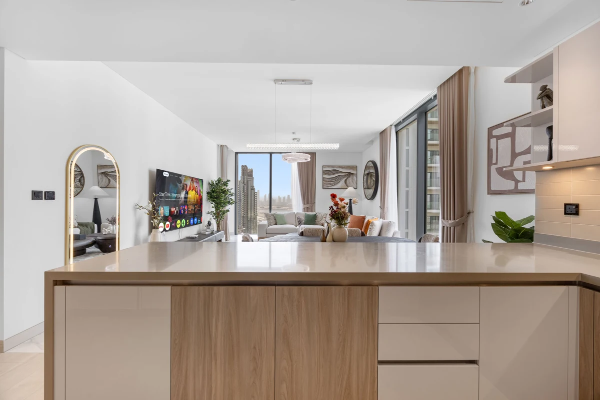 Open-plan kitchen island and dining table of a 3-bedroom Airbnb at Crest Grande, Sobha Hartland, daylight
