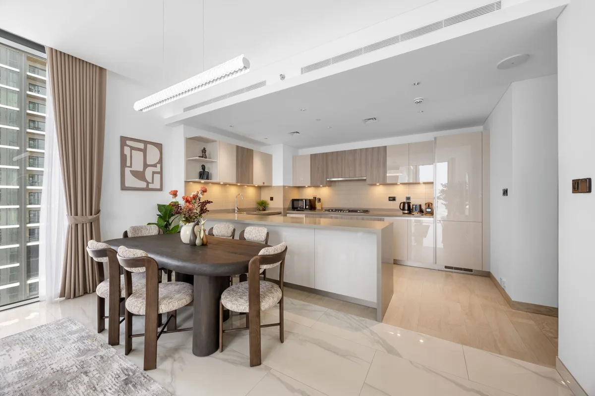 Open-plan kitchen island and dining table of a 3-bedroom Airbnb at Crest Grande, Sobha Hartland, daylight