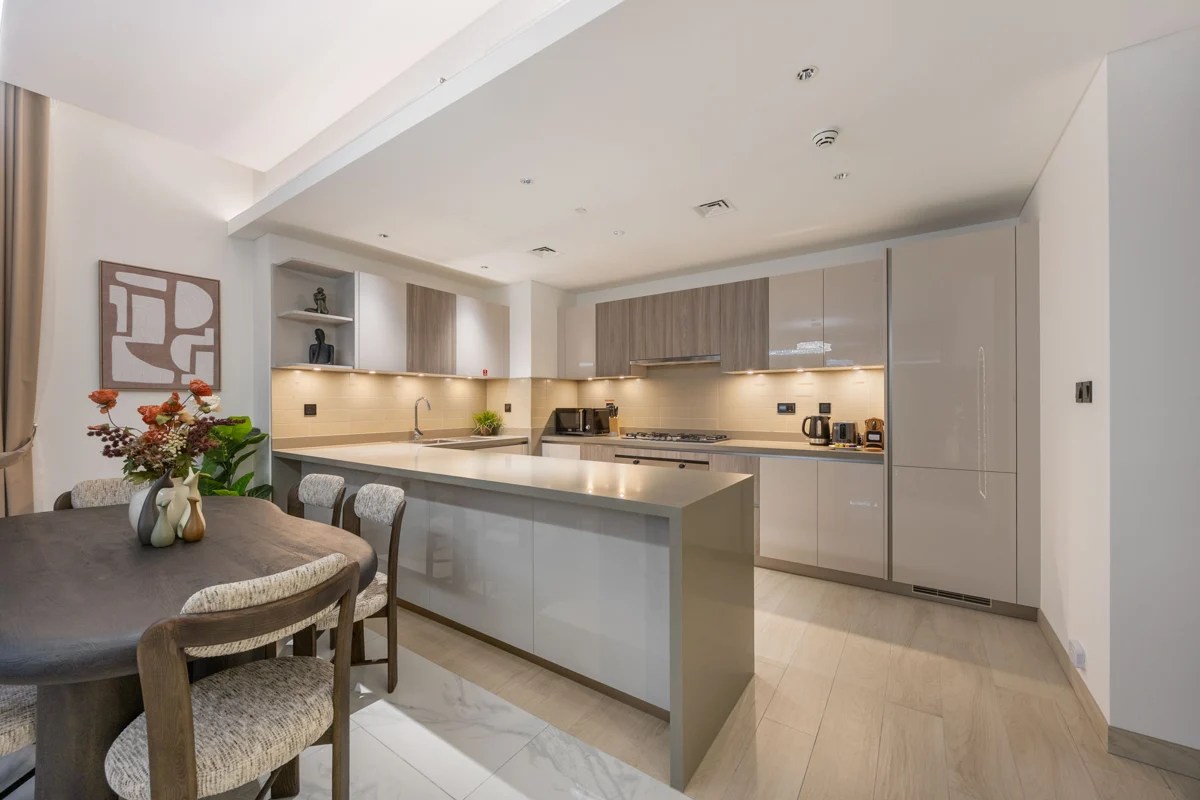 Living room, kitchen and dining at night with city lights, Airbnb at Crest Grande, Sobha Hartland