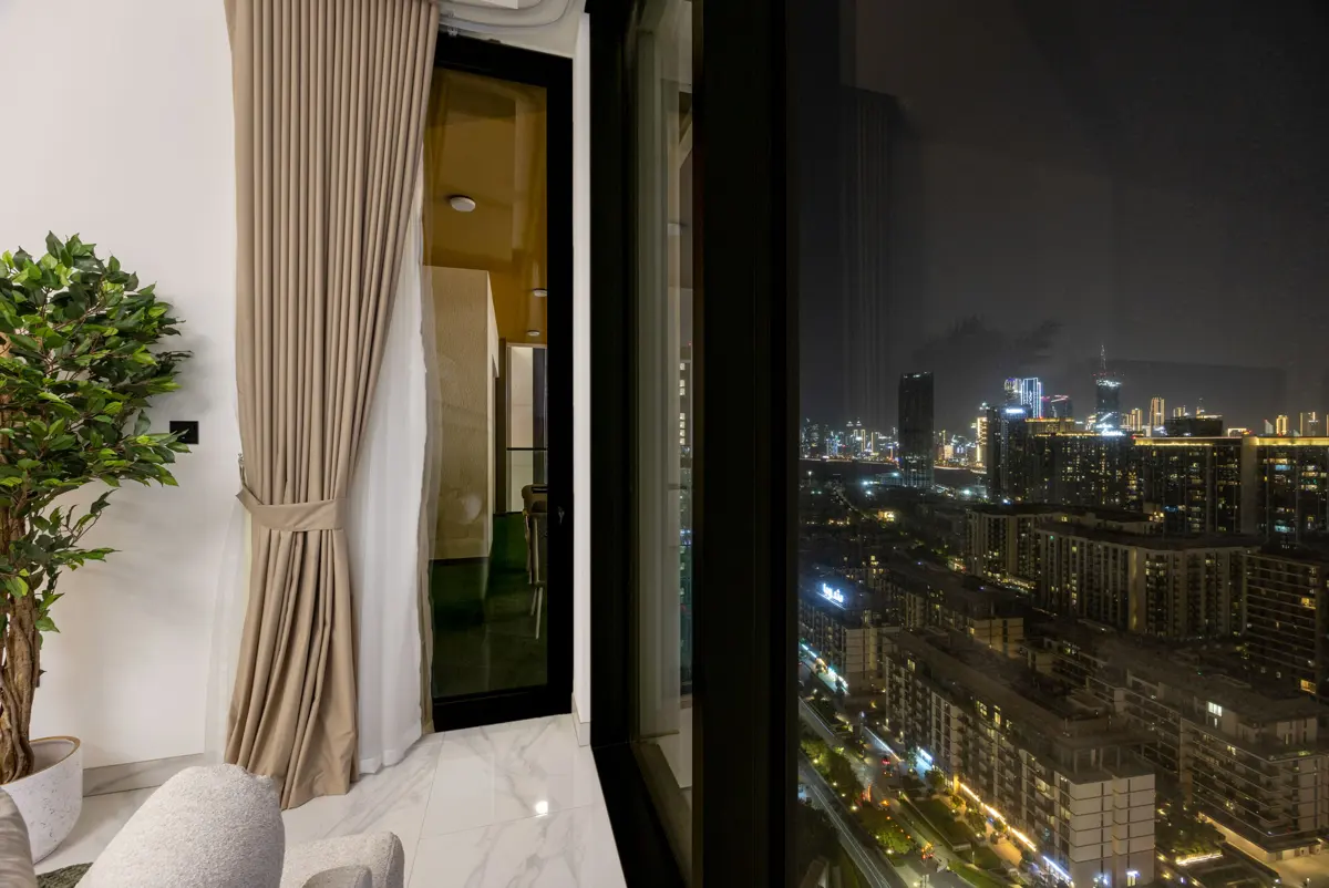 Living room, kitchen and dining at night with city lights, Airbnb at Crest Grande, Sobha Hartland