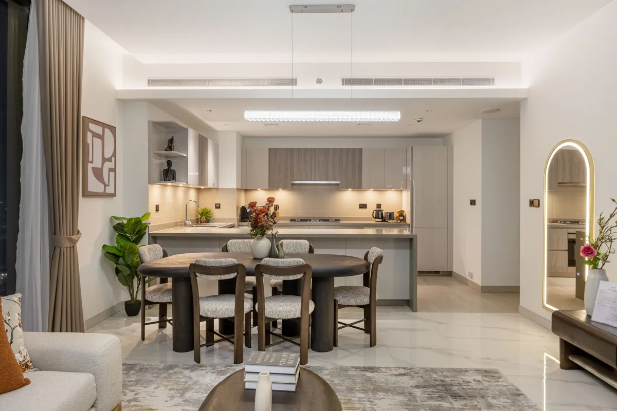 Living room, kitchen and dining at night with city lights, Airbnb at Crest Grande, Sobha Hartland