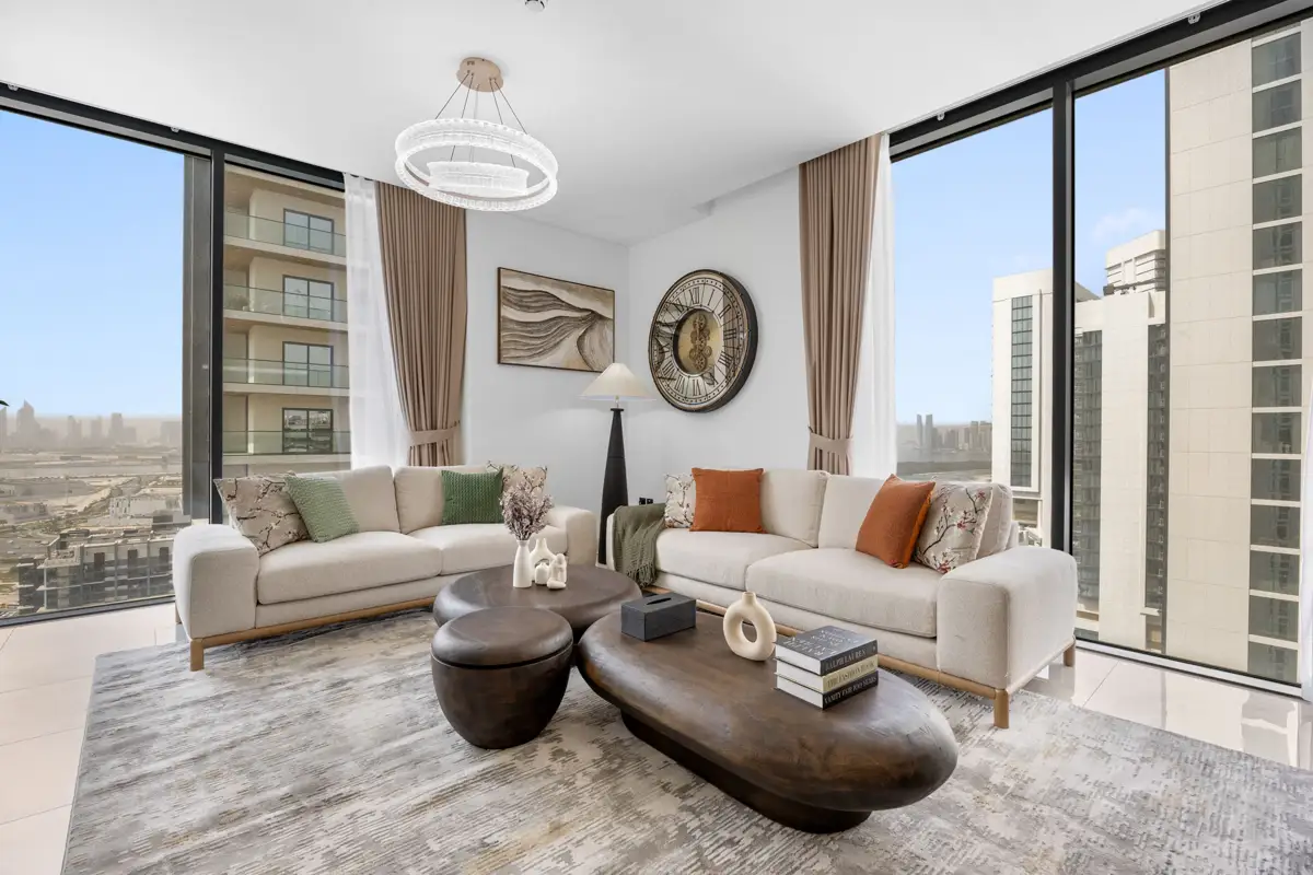 Living room of a 3-bedroom Airbnb at Crest Grande, Sobha Hartland with Burj Khalifa skyline view, daylight