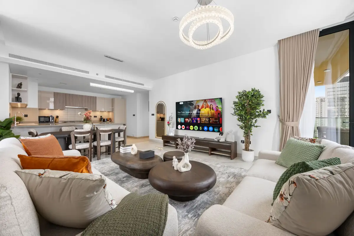 Living room of a 3-bedroom Airbnb at Crest Grande, Sobha Hartland with Burj Khalifa skyline view, daylight