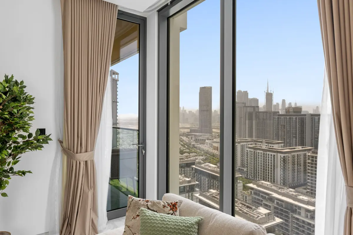 Living room of a 3-bedroom Airbnb at Crest Grande, Sobha Hartland with Burj Khalifa skyline view, daylight