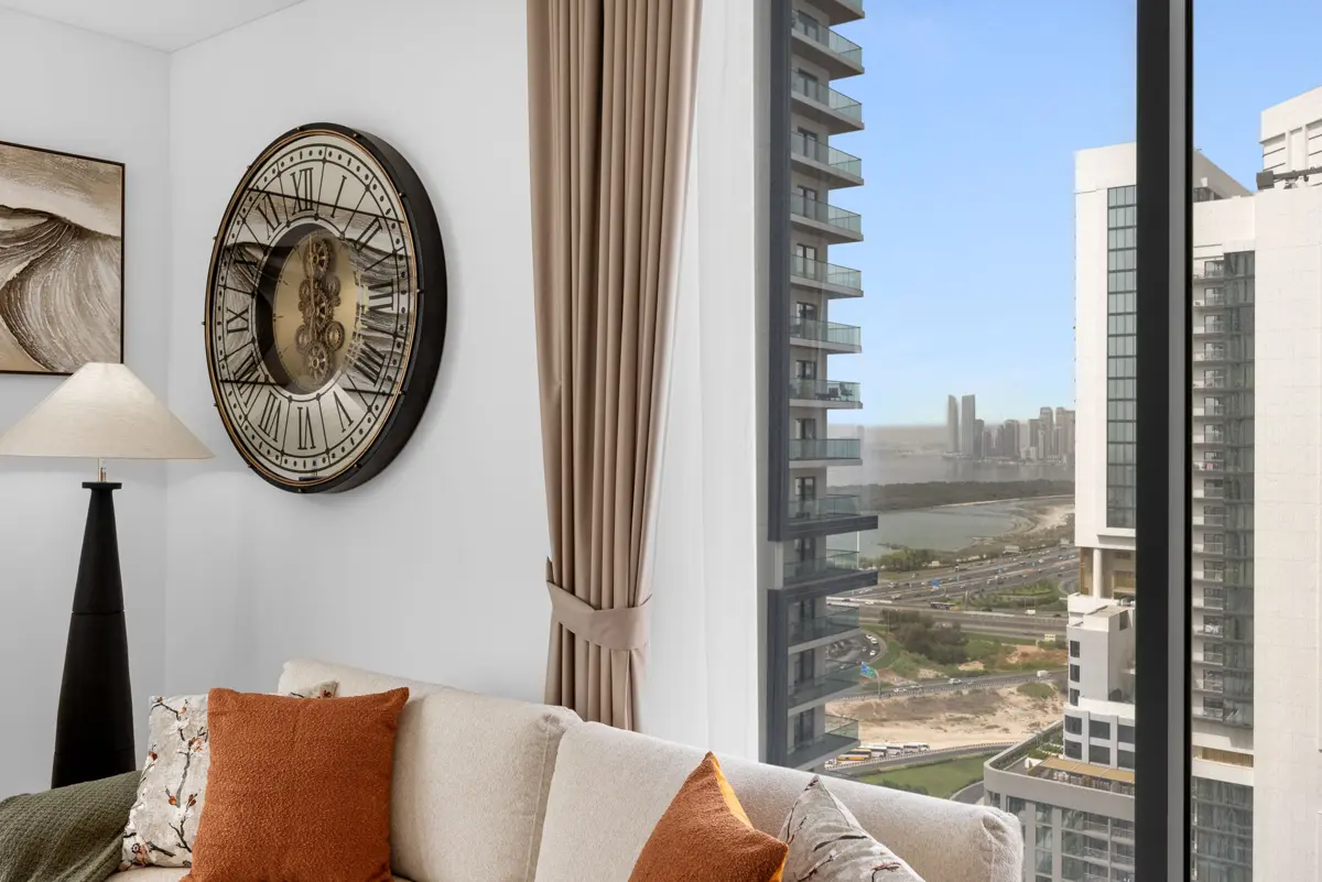 Living room of a 3-bedroom Airbnb at Crest Grande, Sobha Hartland with Burj Khalifa skyline view, daylight