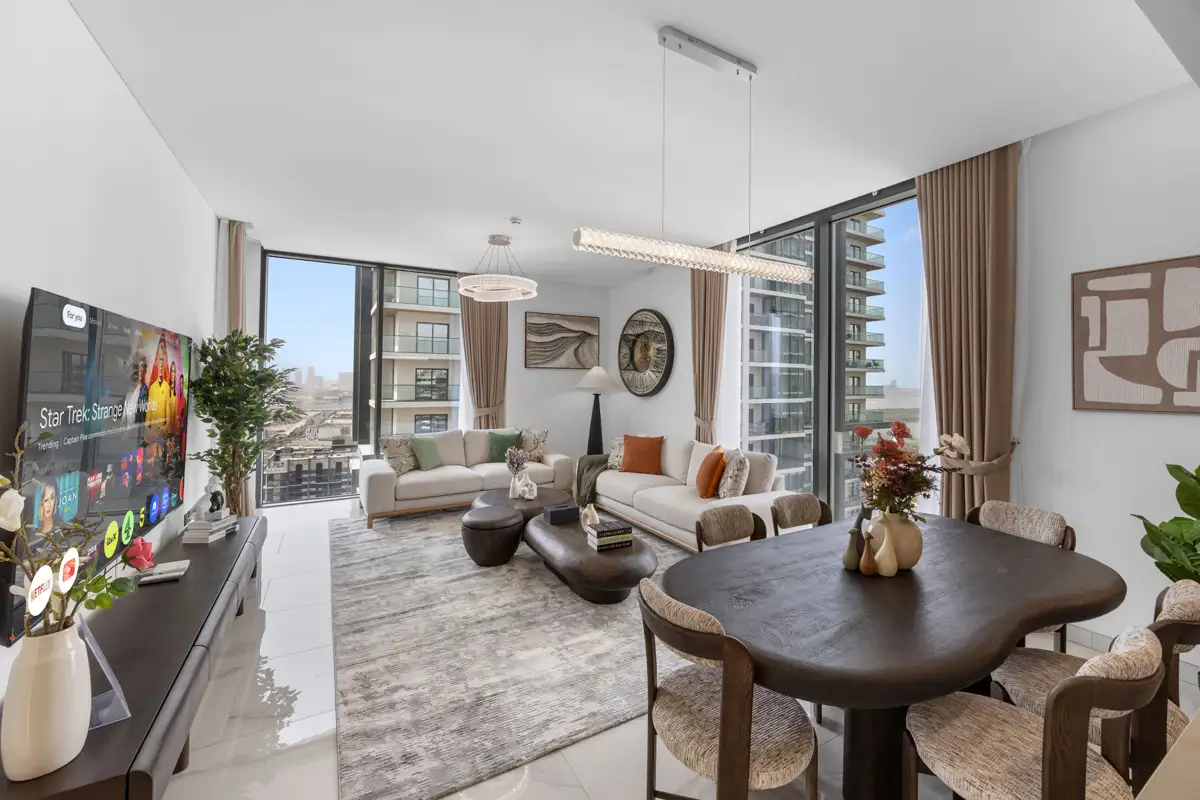 Living room of a 3-bedroom Airbnb at Crest Grande, Sobha Hartland with Burj Khalifa skyline view, daylight