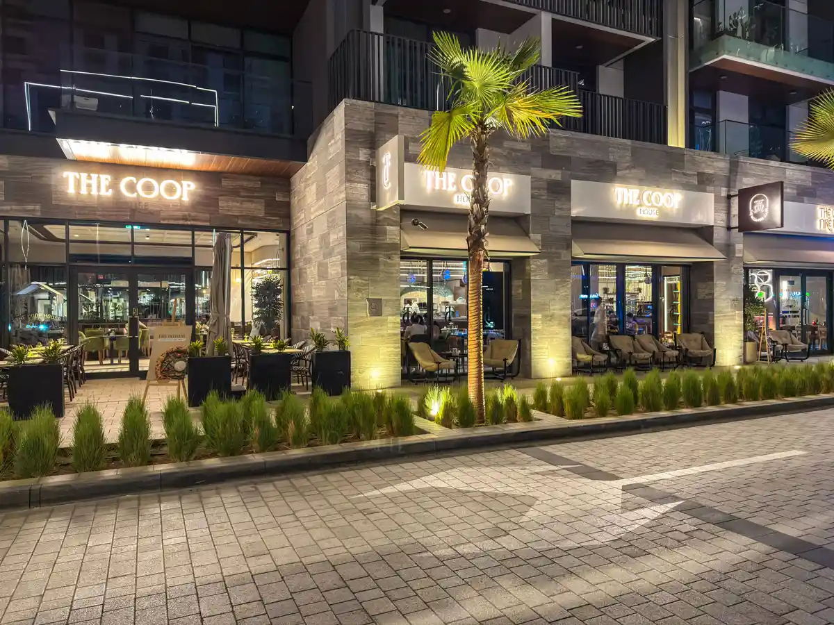 Retail street at Crest Grande, Sobha Hartland at night: The Coop cafe and shops