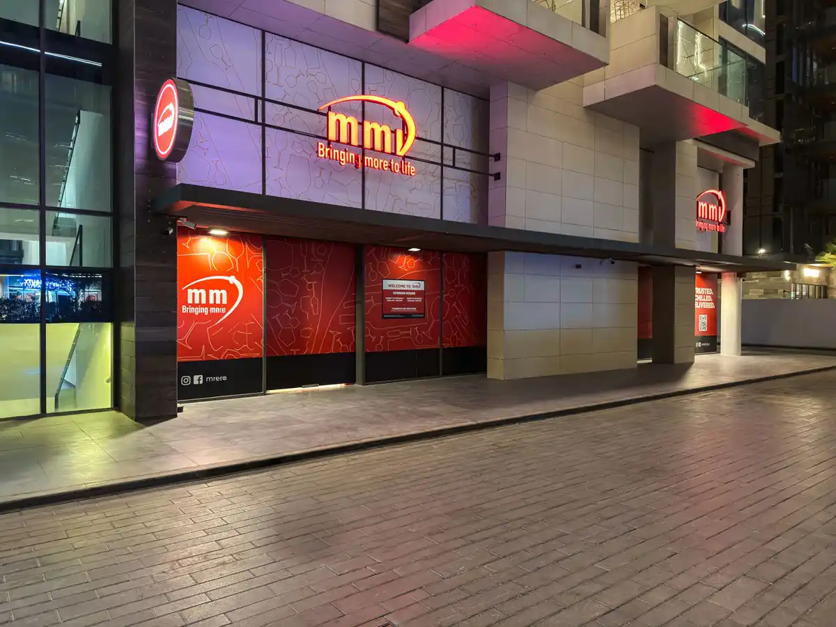 Retail street at Crest Grande, Sobha Hartland at night: The Coop cafe and shops