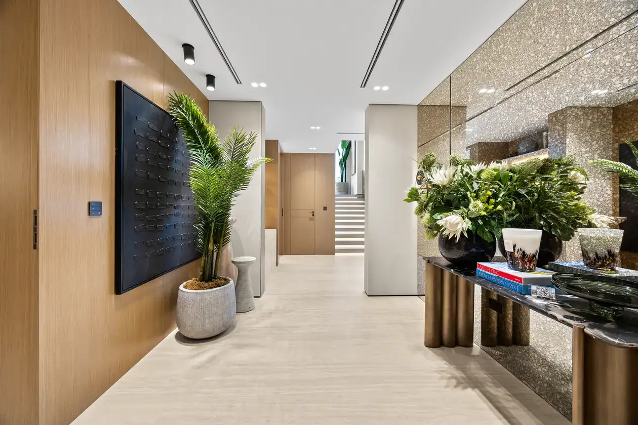 Entrance foyer with a console table, flowers and a mirrored feature wall, luxury villa in Jumeirah Islands, Dubai.