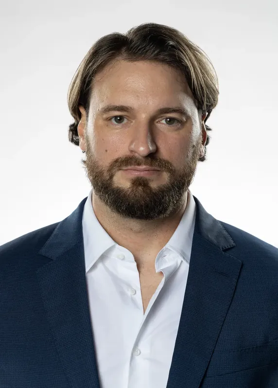 Front-facing neutral headshot in a navy suit. White background reference photo from an AI model training photoshoot at the MRPS studio in Dubai.