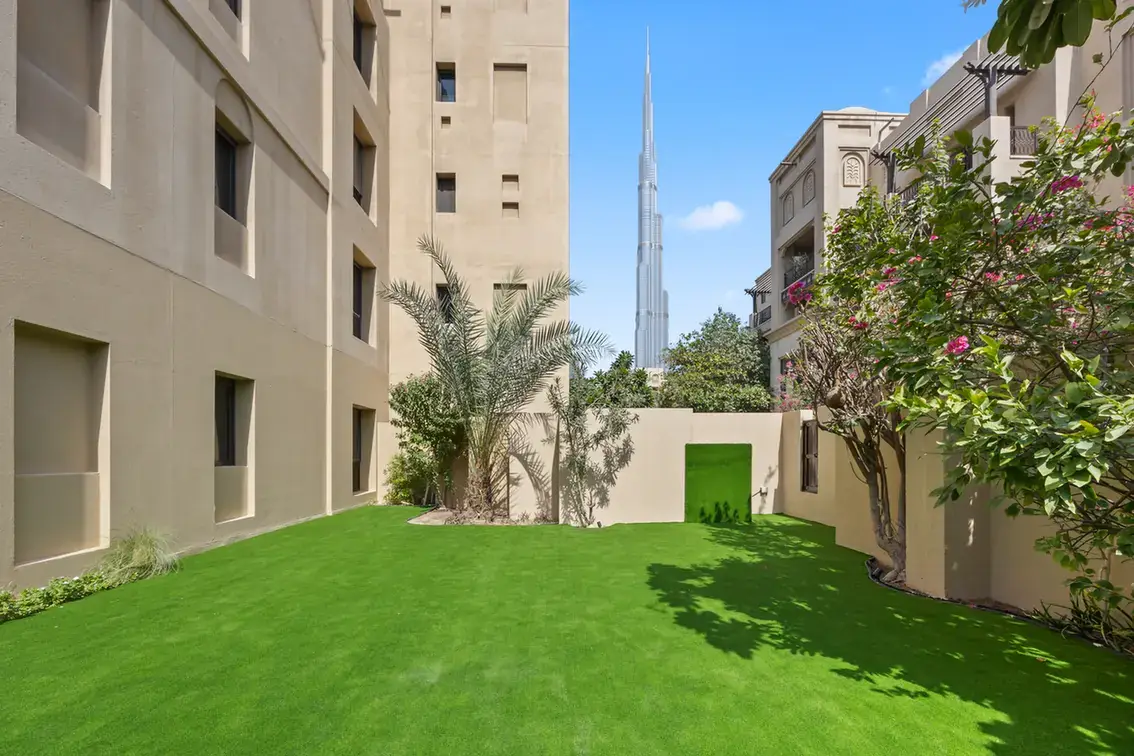 Private lawn garden with the Burj Khalifa rising above the Old Town buildings in an unfurnished two-bedroom garden apartment in Old Town, Downtown Dubai, photographed for ELITE Property Brokerage.