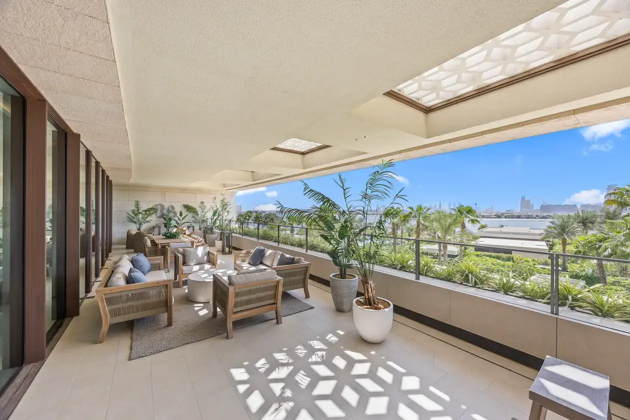 Wide private terrace with lounge seating and garden view in a furnished three-bedroom residence at Atlantis The Royal, Palm Jumeirah, photographed for Apex Homes Real Estate.